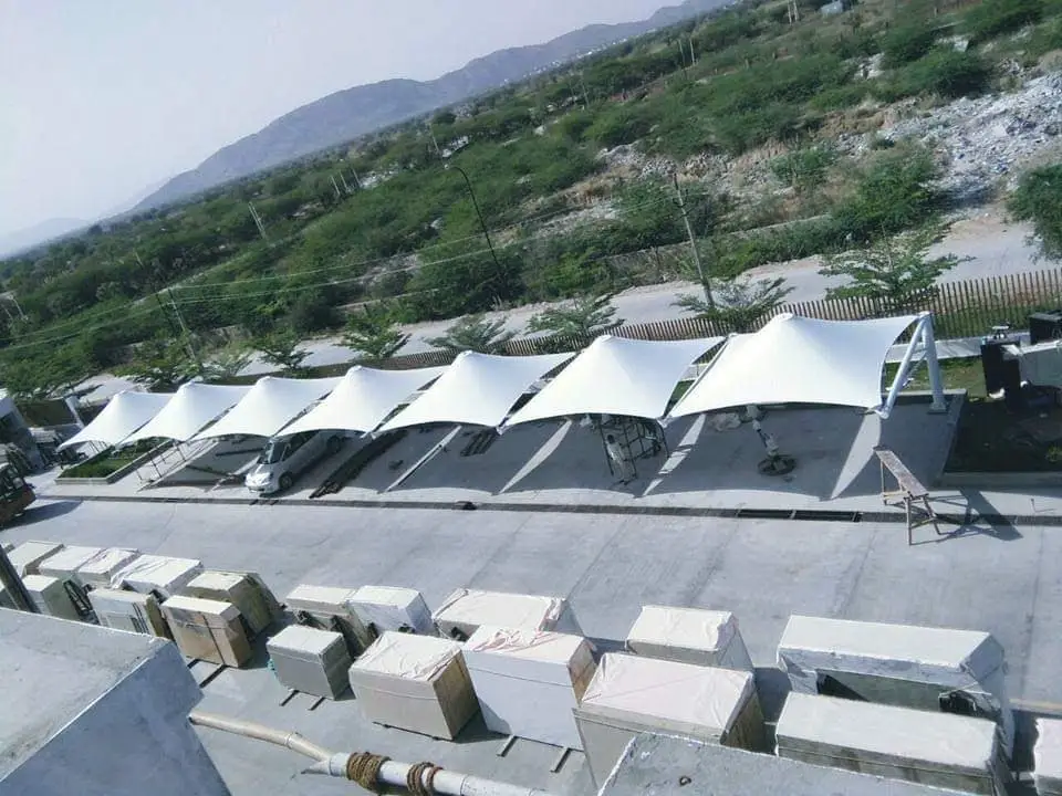 Img20190709wa0053 archilexis | premium tensile structure manufacturer Row of White Tensile Shade Canopies over a Parkingloading Area with Cars Beneath Foreground Shows Stacked Boxes and Pallets